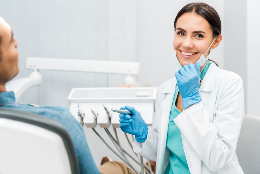 A dentist smiles while providing teeth whitening treatment in Cameron Park