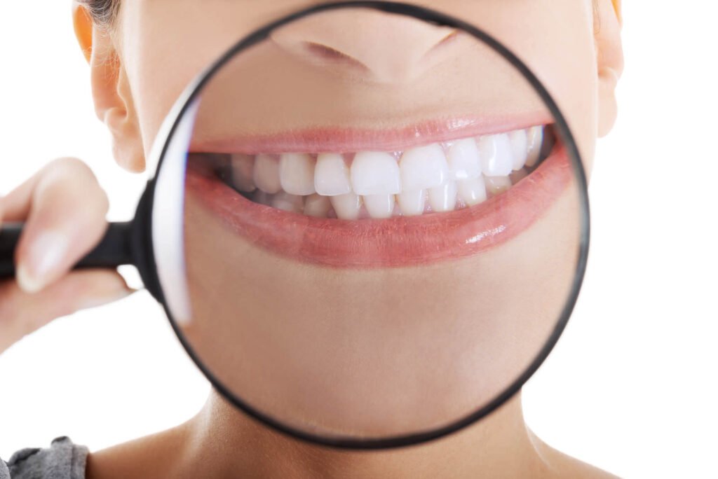 woman with a magnifying glass on her mouth to show the work of her el dorado hills dentist