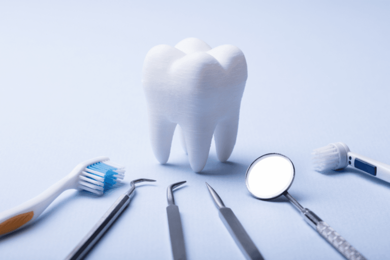 A large tooth model surrounded by dental tools and toothbrushes, emphasizing the Preventing Dental Cavities Guide at Forest Ridge Dental Health & Wellness.