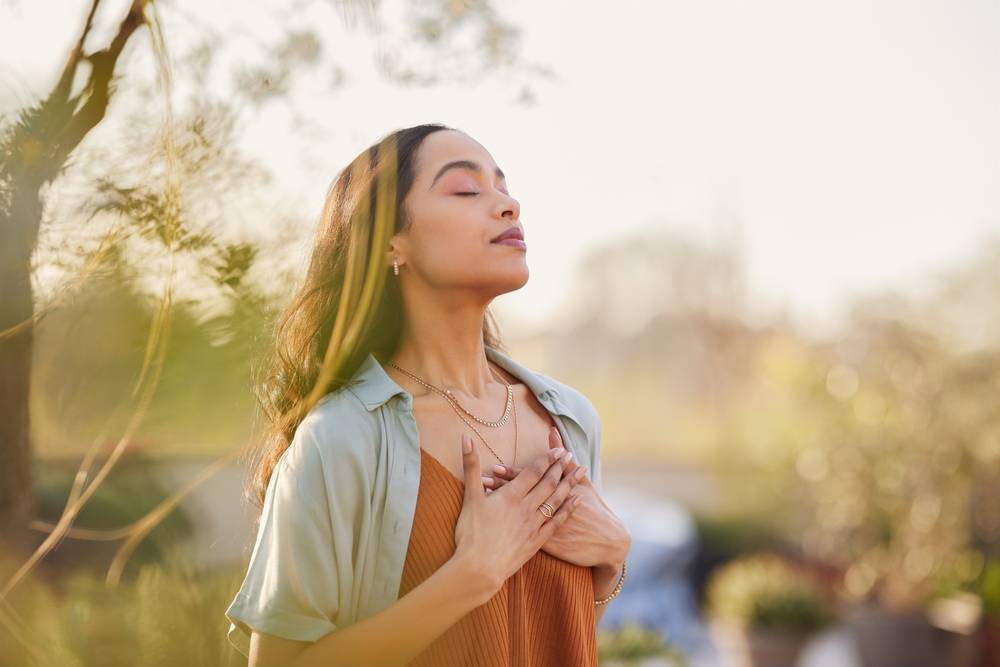 A woman finds peace outdoors, representing the calming effect of Anxiety-Free Solutions at Forest Ridge Dental Health & Wellness